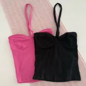 Ribbad halterneck topp i rosa och svart - Två snygga ribbade halterneck toppar i rosa och svart. Använda fåtal gånger.