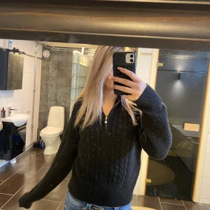 Svart stickad tröja med dragkedja - Säljer en svart stickad tröja med dragkedja framtill och kabelstickat mönster. Tröjan har lång ärm och en lite oversized passform, perfekt för lager-på-lager. Snygg och enkel att matcha till olika outfits.💗