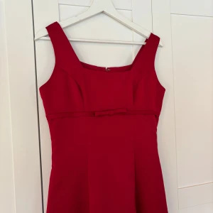 Röd balklänning med breda axelband och rosettdetalj - Superelegant mörkröd balklänning men rosettdetalj i tjockt glansigt material, lapp saknas men uppskattar storlek S-M, skickar gärna mått om det önskas! 🌹💃🏼👠