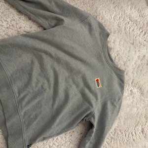 Grå sweatshirt från Fjällräven - Säljer en stilren grå sweatshirt från Fjällräven med klassisk logga på bröstet. Säljer den pågrund av att den är för lite för mig nu eftersom jag fick den när jag var yngre. Jätte fin kvalite har bara använt en gång. Den är köpt på Fjällräven, har den i women i storlek S.🥰🥰
