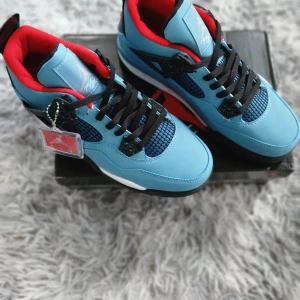 Nike Air Jordans i blått och svart - Säljer ett par Nike Air Jordans med blå ovandel, svarta detaljer och röd insida. Skorna har svarta snören, vit och svart sula samt meshpaneler på sidorna. Ikonisk Jumpman-logga syns på hälen och sulan. Perfekta för dig som gillar streetwear.