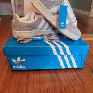 Adidas Campus 00S Grå - Helt nya oanvända Campus i grå med både vita och gråa snören. Storlek 37.5 fortfarande i boxen. Boxen är lite skadad från frakt.