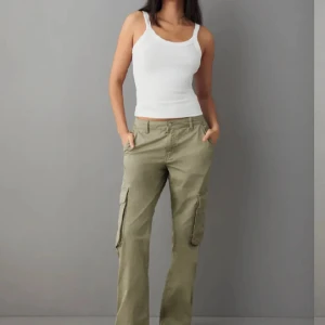 Gröna cargopants lowwaist - Säljer ett par low waist gröna cargopants med raka ben och flera fickor på sidorna. Byxorna har normal passform och sitter snyggt, säljer dom pga dubbelköp 