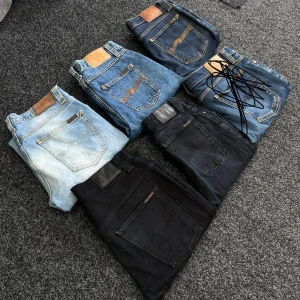 6 stycken nudie jeans  - Säljer sex par Nudie Jeans i olika blå och svarta tvättar. Modellerna har klassiska bakfickor med broderad våg och läderpatch i midjan. Finns både ljusblå, mellanblå, mörkblå och svarta jeans. Passar dig som gillar stilrena och tidlösa jeans.