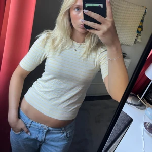 Randig topp  - Säljer en super gullig topp från Lindex i storlek XS. Toppen är gul och vit med tunna ränder, har rund hals och lite längre ärmar. Materialet är mjukt och skönt bomull.
