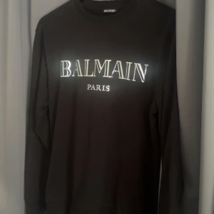 Svart Balmain Paris sweatshirt - Svart balmain sweatshirt i super fräscht skick. Inga täcken på användning och är i princip som ny. Självklart äkta. 
