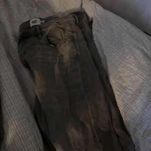 Grå jeans lager 157 split - Säljer ett par grå jeans från 157 med klassisk femficksdesign och raka ben. Jeansen har en neutral grå färg och är tillverkade i slitstarkt denim. Passformen är straight och de har normal midja. Perfekt för dig som gillar enkel och clean stil.  Modellen heter split. Storlek XL full  length.  Tyvärr har dom släppt lite där längst ner (finns bild) men inget som stör. 