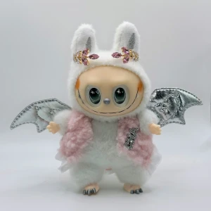 Lafufu Angel Zimomo med gullig väst & diadem  - Jättesöta vita Lafufu Angel Zimomo med silverfärgade vingar och en svans med silverfärgade taggar Hon har på sig en supersöt ljusrosa teddy väst med en strass brosch och ett jättefint guldfärgat diadem i metall med rosa strass stenar Hon har vridbart huvud, händer och fötter Höjd ca 17cm Angel är i jättefint skick, bara stått på en hylla