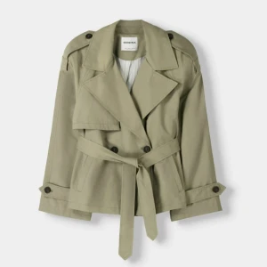 Trendig grön Bershka Trench coat - Skit snygg slutsåld trench coat ifrån Bershka! Helt oanvänd och prislappen sitter kvar, inga defekter över huvudtaget! Säljer jackan då den var lite för stor för mig men väntade för länge så kunde ej skicka tillbaka🥲 ord pris 559kr