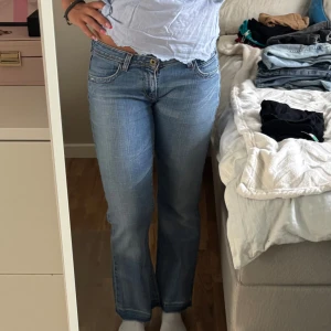 Levis 572 bootcut jeans ljusblå - Säljer ett par klassiska Levis 572 jeans i ljusblå tvätt med bootcut passform. De har låg midja och snygga slitningar vid benslutet. Jeansen är tillverkade i mjukt denim och har Levis röda lapp på bakfickan.