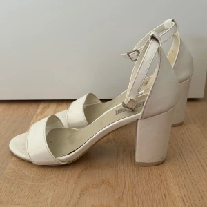 Vita klackarskor - Vita klackar från Nelly. Lite fläckar som ej syns när man har på sig skon, därav priset. supersköna. Strl 36