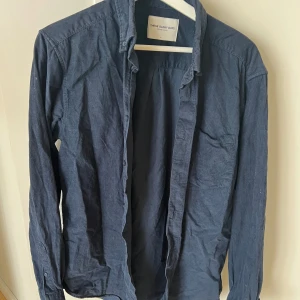 Mörkblå manchesterskjorta M - Mörkblå manchesterskjorta i storleken M från märket These Glory Days. Fint skick och inga tecken på användning. 