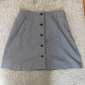 Rutig kortkjol från Monki - Snygg svartvit rutig kjol från Monki i storlek 38.