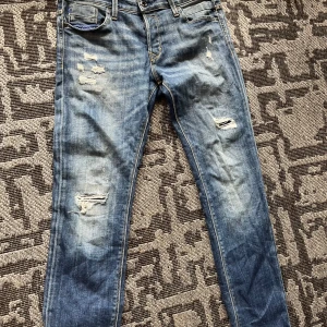Slim jeans från Jack & Jones, blå - Slim Glenn jeans från Jack & Jones i klassisk blå tvätt med slitna detaljer, Modellen har smal passform, 