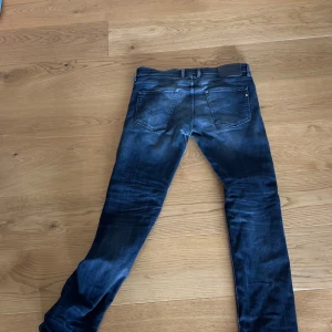 Mörkblå Replay slim jeans - Snygga mörkblå jeans från Replay med slim passform och klassisk femficksdesign. Jeansen har en lätt tvättad look och smala ben, perfekta för en stilren vardagsoutfit. Tillverkade i mjukt jeansmaterial med stretch för extra komfort.