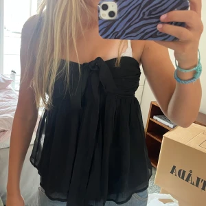 Svart festtopp - Svart topp som man kan ha både som en bandeu topp, men även halterneck om man knyter banden runt halsen