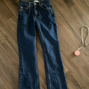 Mörkblå raka jeans - Snygga mörkblå jeans med klassisk femficksdesign och raka ben. Jeansen har normal passform och är tillverkade i robust denim som ger en cool och tidlös look. Perfekta att matcha med sneakers eller boots för en chill stil. Använda en gång, små I storleken och är inte strechiga. 