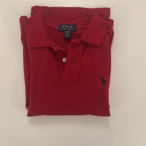 Röd pikétröja från Polo Ralph Lauren -  röd pikétröja från Polo Ralph Lauren✅                    Storlek 10/12 år/ M i barn storlek✅                            Skick 9/10, använd cirka 5 gånger✅                         Passform, custom fit✅                                                   Pris: 199kr nytt pris: 1000kr✅                                      Skriv vid minsta fråga. Priset är ej huget i sten 🕰️