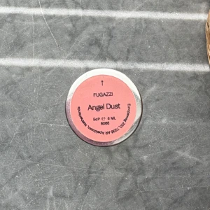Fugazzi Angel Dust EdP 8ml - Säljer en parfym från Fugazzi, Angel Dust EdP i 8 ml sprayflaska. Flaskan är cylinderformad med transparent glas och har ett silvrigt lock med en rosa etikett på toppen. Perfekt storlek för att ta med i väskan. Se bild hur mycket som är kvar. 