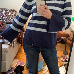 Randig blå stickad tröja  - Säljer en chill stickad tröja från Kappahl i storlek S. Den har breda, ljusblå och mörkblå ränder, rund hals och långa ärmar med lite utsvängda muddar.  Bara använd två gång eftersom den inte är min stil. 