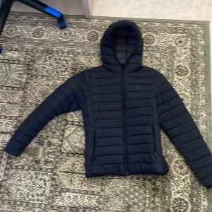 SVART DUNJACKA  - Svart dunjacka från hangTen väldigt snygg och kan combinera många outfits med den väldigt snygg och skön för höst eller vinter inget håll eller fläck.