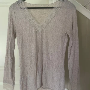 Intimissimi Tröja - Säljer min superfina populära tröja från Intimissimi, i färgen Shell beige blend. V-ringad med fina spetsdetaljer både vid halsringningen och ärmsluten.  Använd endast en gång, säljer då den är för stor. Superbra skick, inga fläckar eller defekter. Nypris 559kr