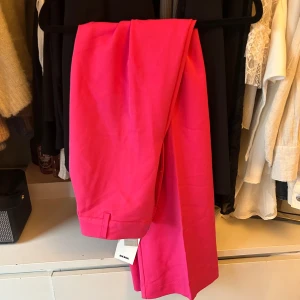 Rosa byxor från BikBok - Snygga rosa byxor från BikBok i en härlig färg. De har en hög midja och en slim passform som framhäver figuren. Perfekta för att lägga till en färgklick i garderoben.