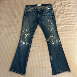 Jeans med slitningar  - Skitsnygga jeans med slitningar. Köpte second hand men var tyvärr för små för mig. Finns en liten fläck på låret som inte verkar gå bort. Skriv vid frågor och kolla gärna min profil för fler jeans 🤩
