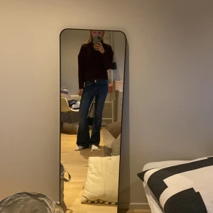 Blå bootcut jeans med stjärndetaljer - Snygga blå bootcut jeans med unika stjärndetaljer på bakfickorna. Perfekta för en avslappnad stil med en twist. De har en klassisk femficksdesign och stängs med dragkedja och knapp.