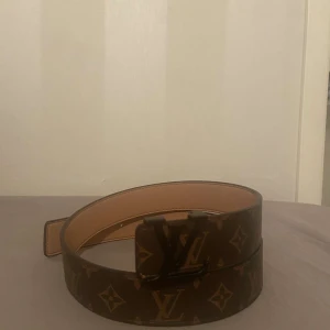 Brunt bälte från Louis Vuitton - Snyggt brunt bälte från Louis Vuitton med det klassiska monogrammönstret. Bältet har en stilren LV-spänne i metall som ger en lyxig touch. Perfekt för att lyfta vilken outfit som helst.