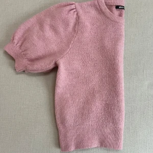 Rosa stickad tröja från Gina Tricot - Säljer en söt rosa stickad tröja från Gina Tricot. Tröjan har korta puffärmar och en rund halsringning. Varan är väl använd men är i bra skick och har tagits bra hand om.  Som det kan ses på bilderna är tröjan lite nopprig på grund av tvättning men det är ingenting som syns tydligt. Nypris 400 men säljer för 100, strl S.   