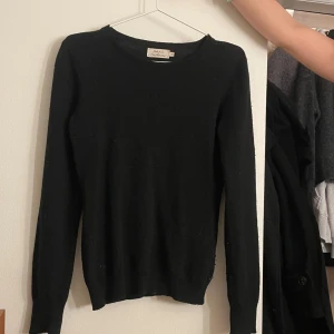Svart tröja från Uniqlo - Säljer en stilren svart tröja. Tröjan har långa ärmar och en klassisk rund halsringning. Perfekt för en minimalistisk look. Passar till många olika outfits!