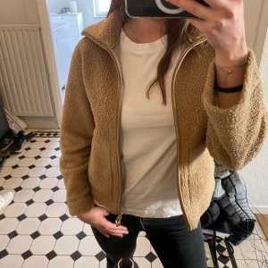 Beige teddyjacka med dragkedja - Mysig beige teddyjacka med dragkedja framtill. Säljer då den inte kommer till användning!💕