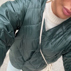 Grön quiltad jacka - Säljer en snygg grön quiltad jacka med lång ärm och en stilren design. Jackan har en oversized passform endast använd ca 3 gånger 