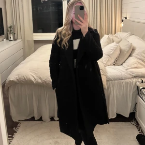 Svart kappa - Svart lång kappa i teddymaterial från HM. Använd fåtal gånger och i väldigt bra skick. Storlek XS.