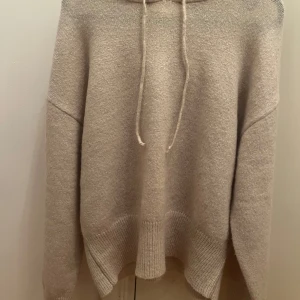 Beige hoodie från Gina Tricot - Mysig beige hoodie från Gina Tricot med långa ärmar och justerbar dragsko i huvan. En stilren och enkel design som passar till det mesta.