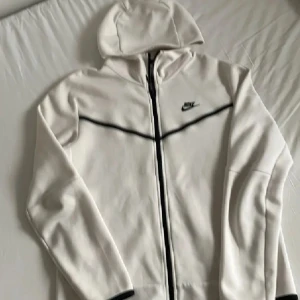 Vit hoodie från Nike - Säljer en stilren vit hoodie nike tech storlek M