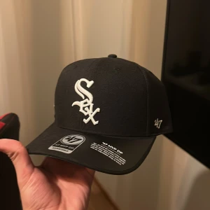 47 Chicago white Sox Svart keps - En helt ny oanvänd new era keps. Väldigt snygg. Även till valt en patch med två öl glass som ni kan se på bild 2.                                                          Är ni sugna på en ny snygg keps så slå till. Priset kan diskuteras. Skriv gärna om ni har några frågor. 