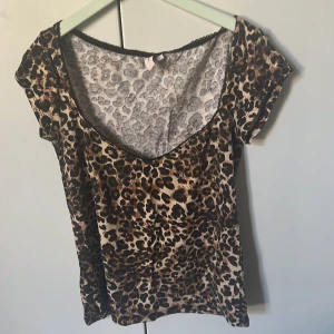 Leopardmönstrad topp från Nelly - Säljer en snygg leopardmönstrad topp från Nelly. Toppen har en djup v-ringning och korta ärmar.🐆🥰 Den är i storlek M men passar mig som har storleken S. 