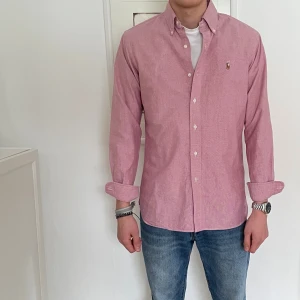 Rosa Ralph Lauren skjorta - Snygg rosa skjorta från Ralph Lauren med klassisk krage och knappar framtill. Perfekt med både jeans och linnebyxor i sommar! Funkar bra till storlek M också. 