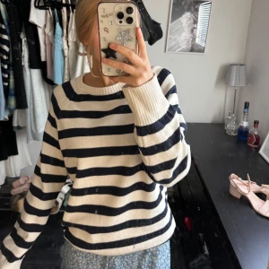 Randig stickad tröja - Säljer en mysig randig stickad tröja i svart och vit från bikbok. Tröjan har långa ärmar och en rund halsringning. Nästan aldrig använd och precis som ny