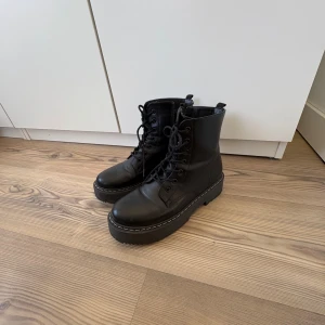 Svarta boots med snörning - Snygga svarta boots i skinn med snörning och robust sula. Perfekta för en edgy look och passar bra till både jeans och kjol. De har en klassisk design med en modern twist.