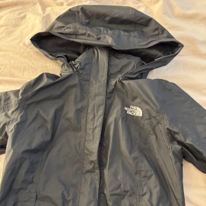Svart regnjacka från The North Face - hej! säljer min svarta regnjacka från The North Face med huva och dragkedja. den har en jättefin passform, stl xs. 350kr, men pris kan diskuteras! hör av er vid funderingar🫶🏻
