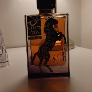  LattafaOud Lail Maleki Parfym100 ml pris kan diskuteras - PÅMINNER OM XERJOFF NAXOS!Elegant parfymflaska med en kraftfull hästdesign. Flaskan är rektangulär med en gyllene och svart färgpalett, vilket ger en lyxig känsla. Perfekt för den som söker en unik doftupplevelse.