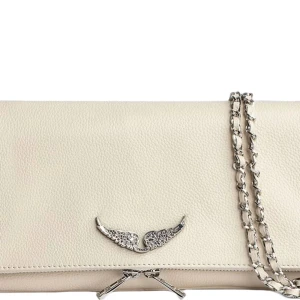 Beige Zadig väska - Snygg vit axelväska med en elegant kedja som axelrem. Väskan har en dekorativ detalj i form av vingar på framsidan. Perfekt för att ge din outfit en stilren touch.