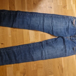 Blå jeansbyxor Diesel - Snygga blå jeansbyxor med klassisk design. De har en rak passform och är perfekta för en avslappnad stil. Byxorna har fickor både fram och bak samt en knapp- och dragkedjestängning.