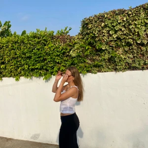 Vit linnetopp med knytband - Säljer en stilren vit linnetopp med smala axelband som knyts. Toppen har en enkel design och är perfekt för varma dagar. Materialet är lätt och luftigt, vilket gör den bekväm att bära.