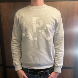 Tröja från A.P.C. - Säljer en stilren grå sweatshirt från A.P.C. med deras ikoniska logga tryckt på framsidan. Tröjan har inga som helst defekter och säljs eftersom att storleken inte passade mig. Hör av dig vid minsta lilla fundering!