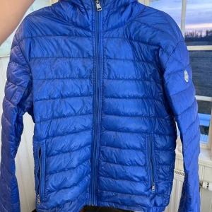 Blå dunjacka från Moncler - Säljer en snygg och unik blå dunjacka från Moncler. Den är i bra skick. Av de äldre modellerna så vet ej namn osv. Bara jackan som med följer. Köpt på garmsmarket för länge sedan. Storlek S eller liten M