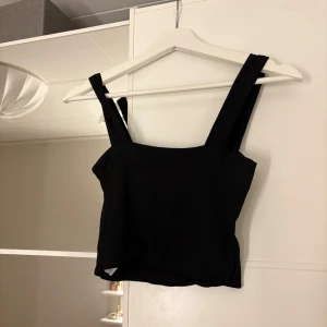 Svart ribbad linnetopp - Snygg svart ribbad linnetopp med breda axelband. 